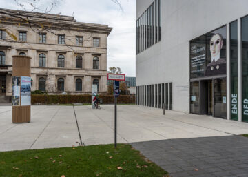 Litfaßsäule mit Ausstellungsplakat vor NS-Dokuzentrum